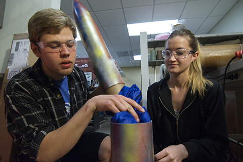 Two aerospace engineering students working on a rocket