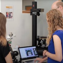 Neuroengineering reserachers standing around a screen and a device