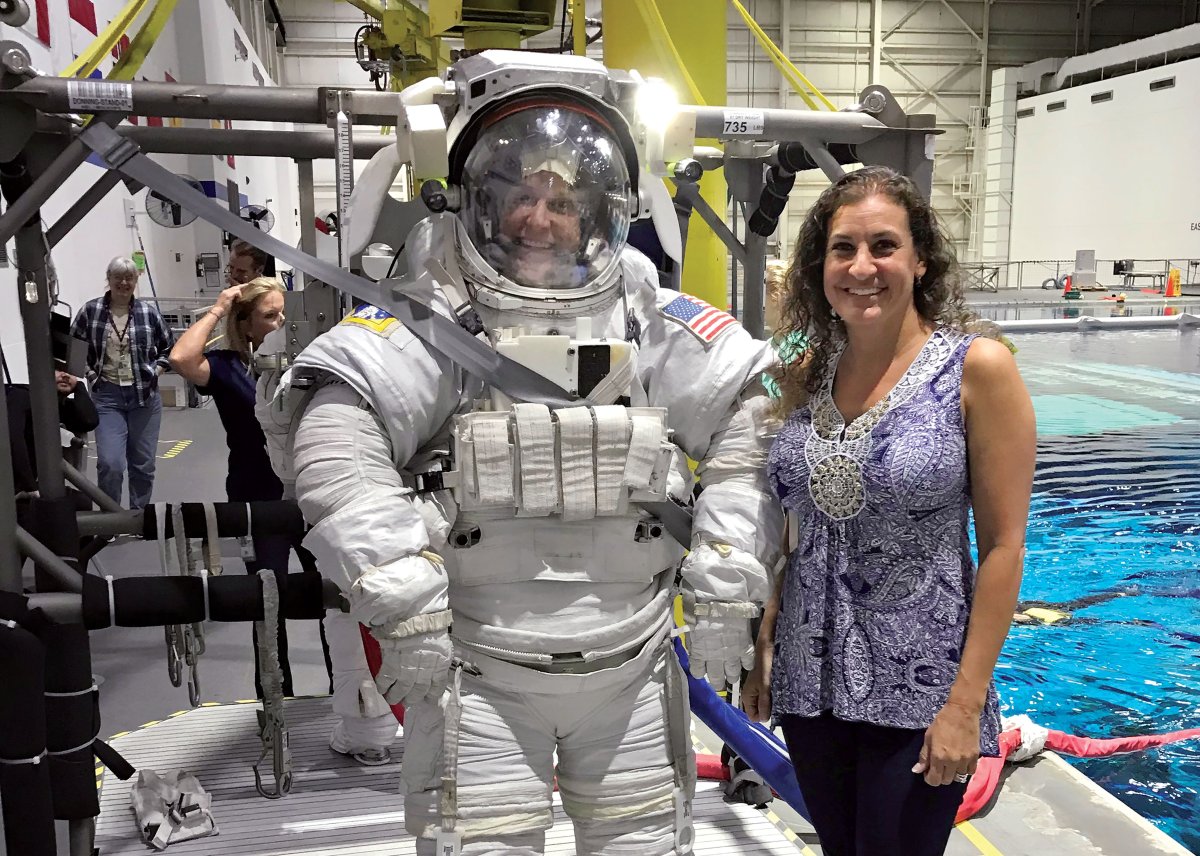 Heather McDonald standing next to an astronaut in a spacesuit.