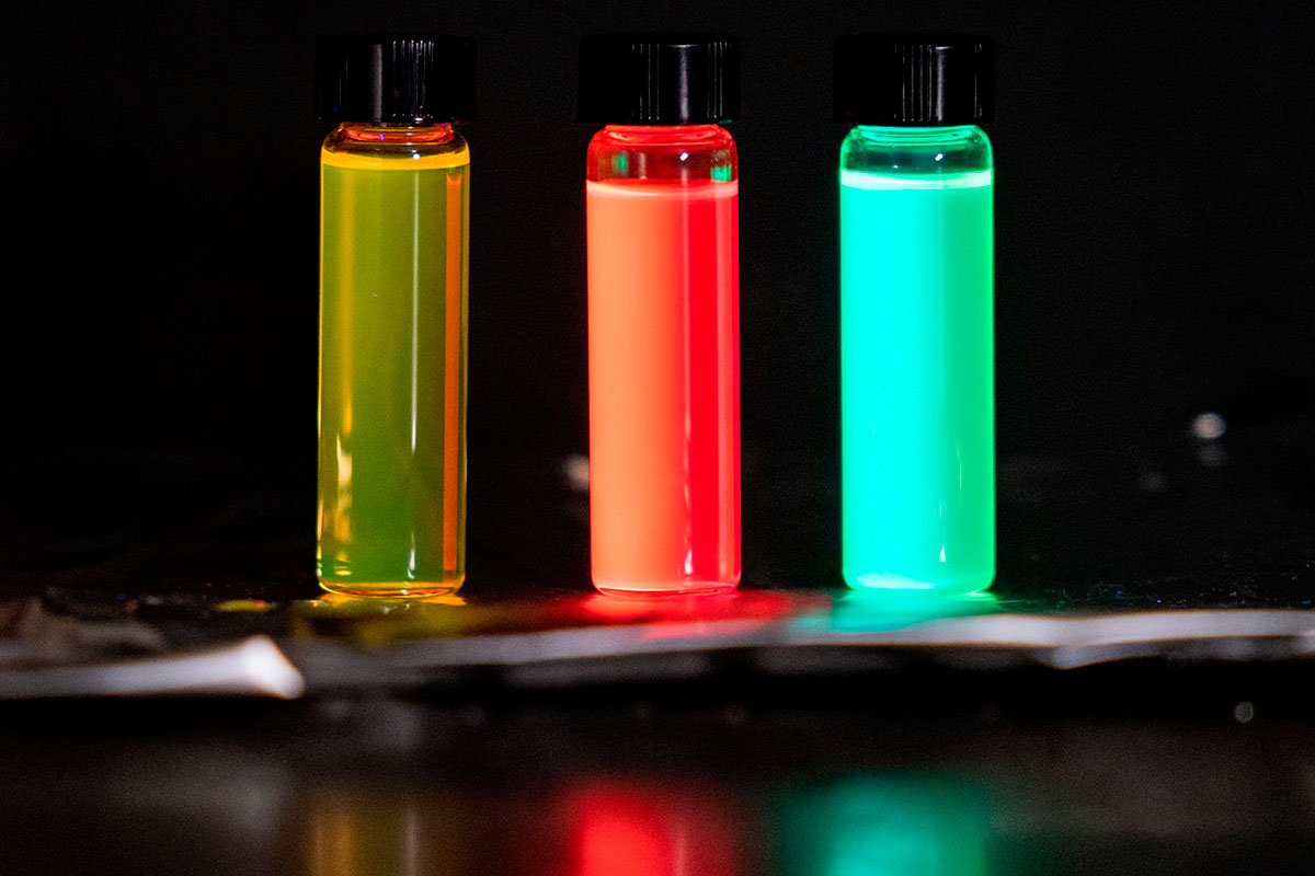 Three vials glow different colors: yellow, red, green