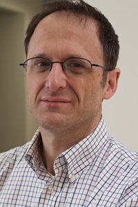 A man in a white shirt wearing glasses