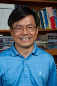 man wearing bright blue shirt in front of bookshelf