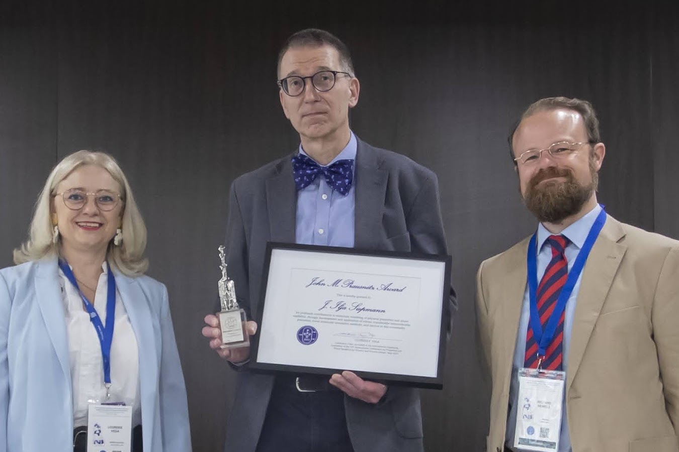 Prof. Siepmann standing with an award certificate next to two other individuals.