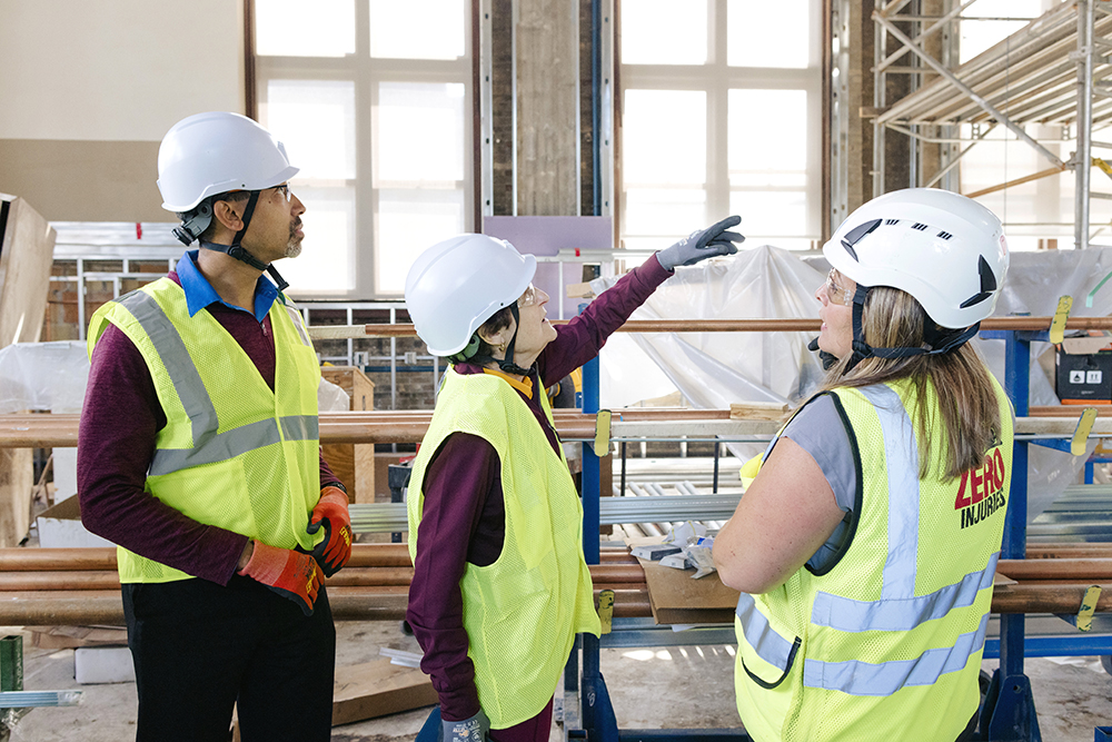 Françoise deRochefort Thompson pointing to the Gregory Thompson Floor construction with CSE Dean Andrew Alleyne and Jessica Deitner, Mortenson Senior Project Manager