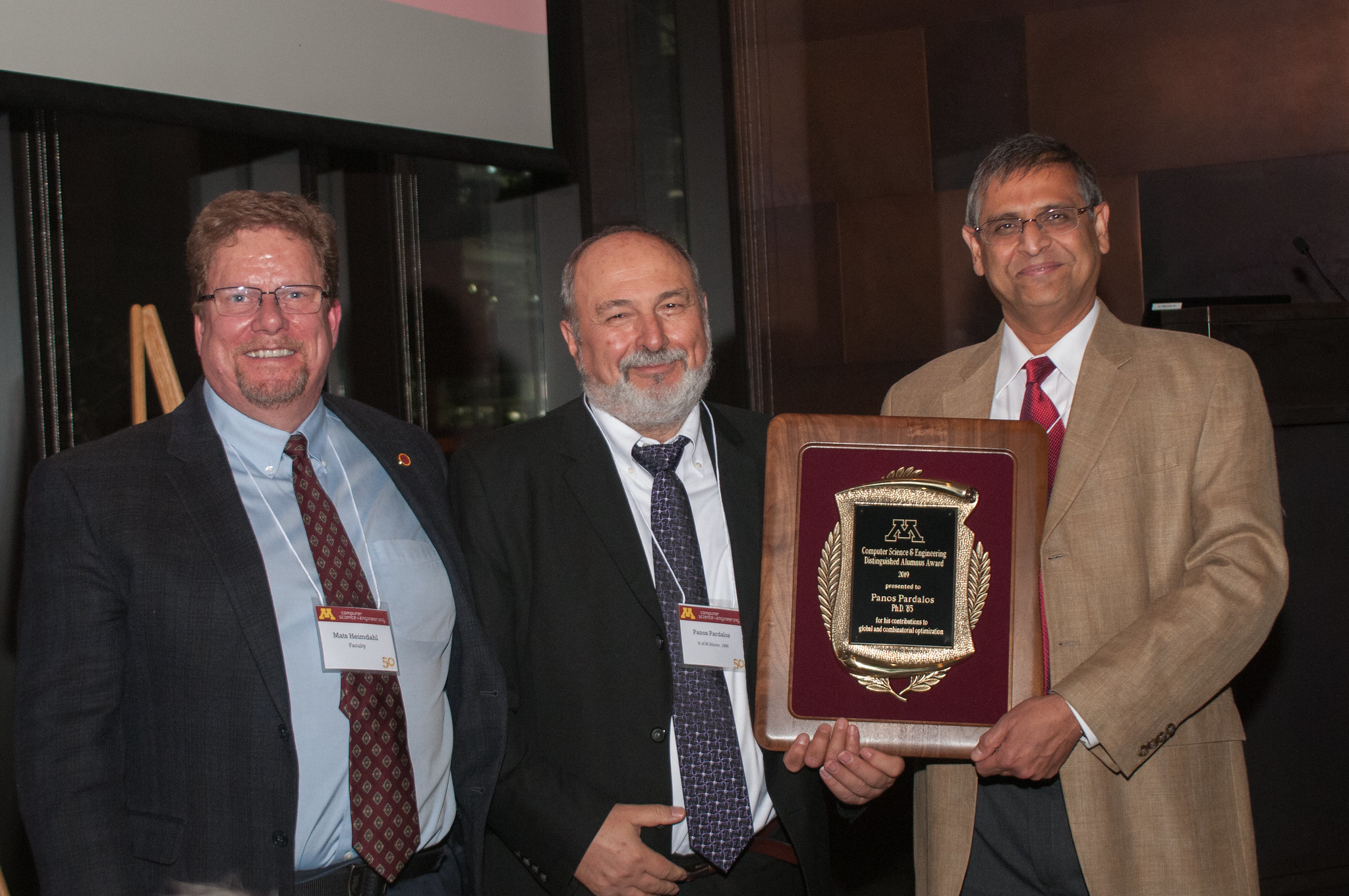 Mats Heimdahl and Vipin Kumar present Panos Pardalos with the 2019 Distinguished Alumnus Award