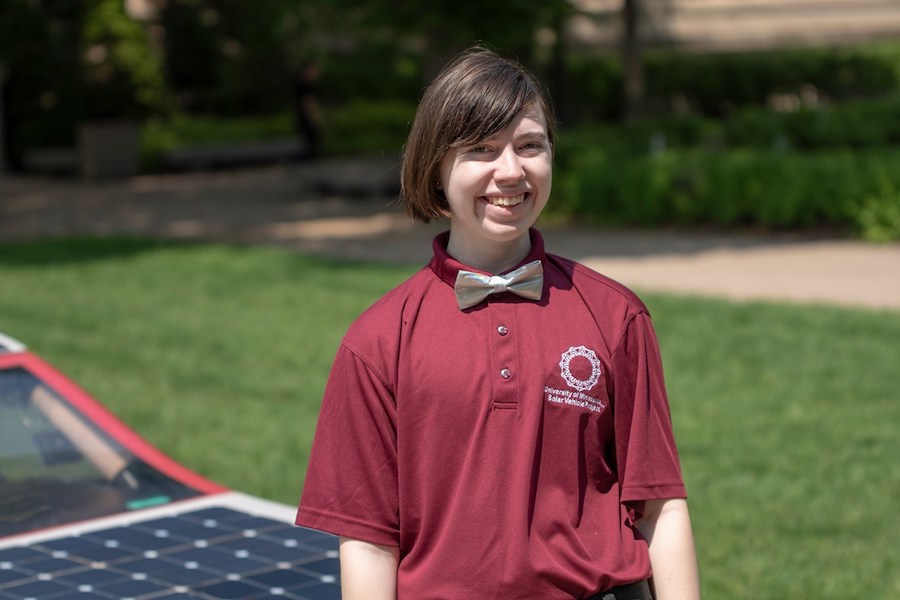 CSE student Amethyst O'Connell poses in front of the Solar Vehicle Project's sun-powered car