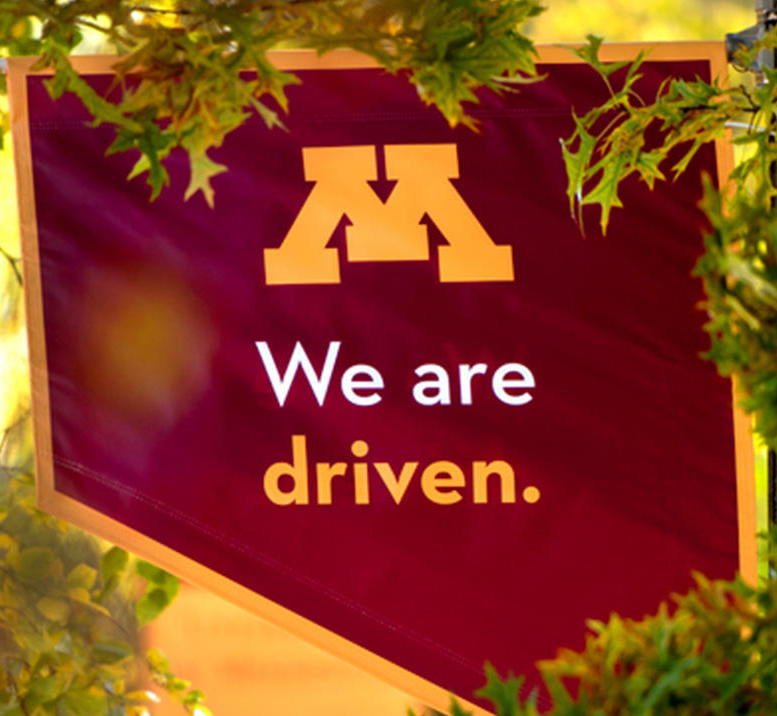 Banner that says "We are Driven" with the University of Minnesota "M" logo