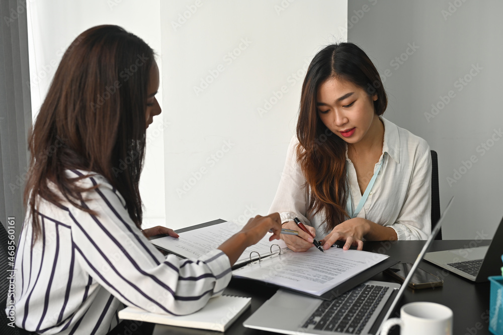 Two women writing a resume 