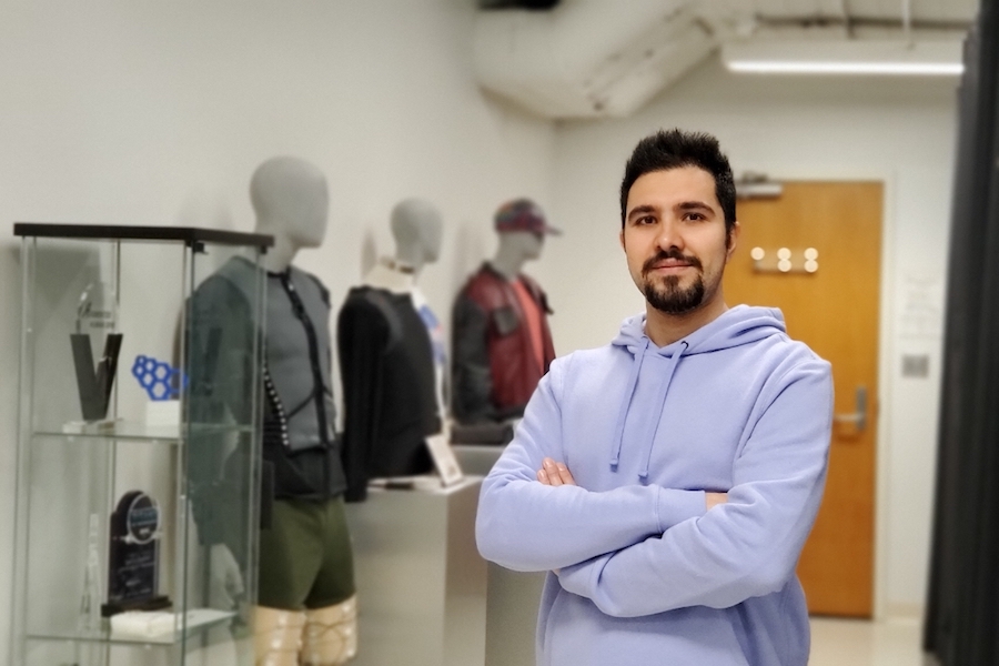 Ph.D. student Alireza Golgouneh poses next to several wearable devices he helped create