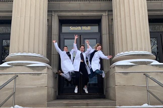 chemistry majors jumping for joy on the steps of Smith Hall
