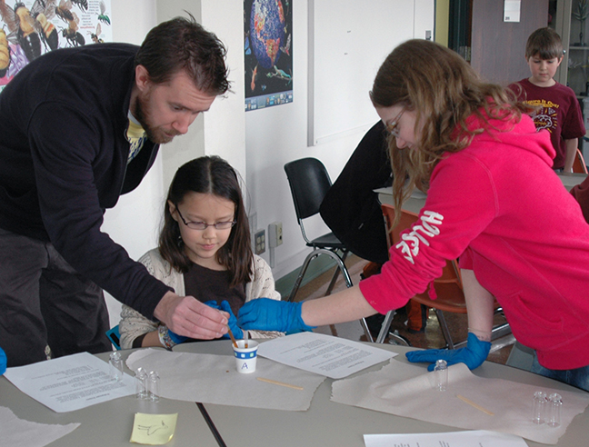 Adults working with students on experiments