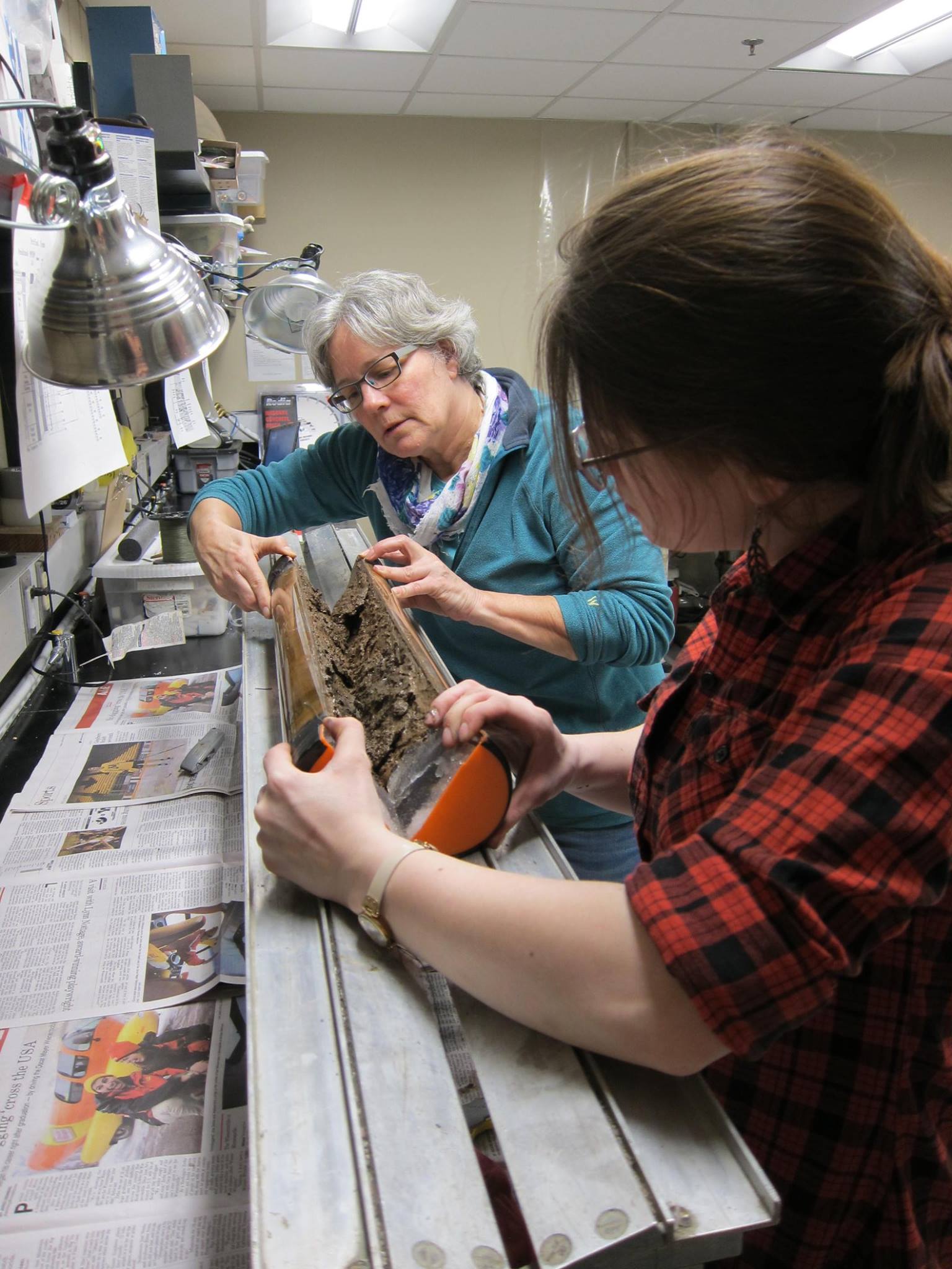 Two women opening up a sediment core section