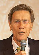 Picture of person in a suit holding a microphone