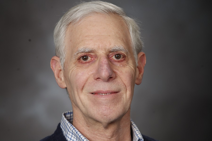 Professor Gerald Sobelman indoors in a dark sweater smiling into the camera