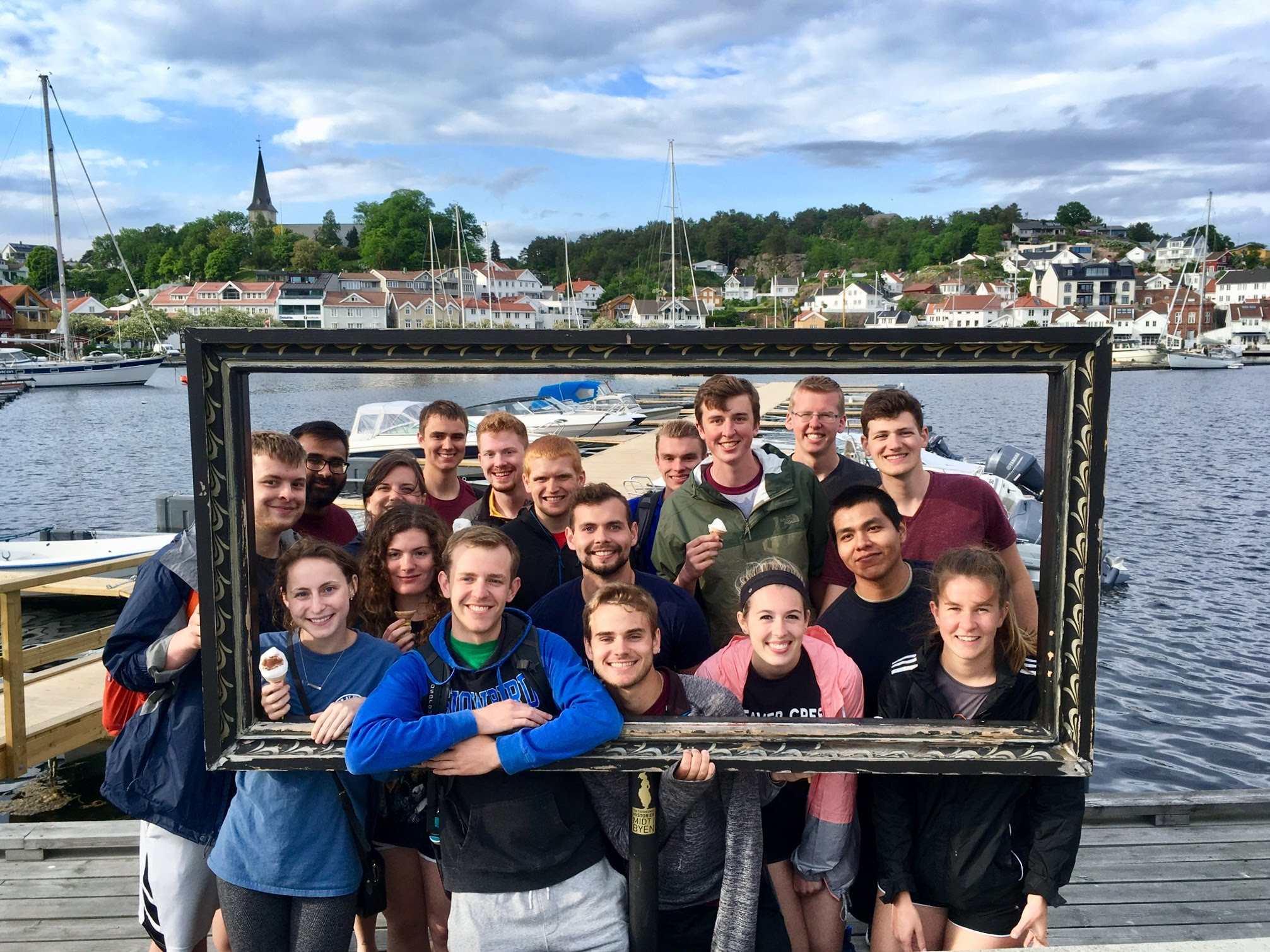 Students in picture frame in front of water