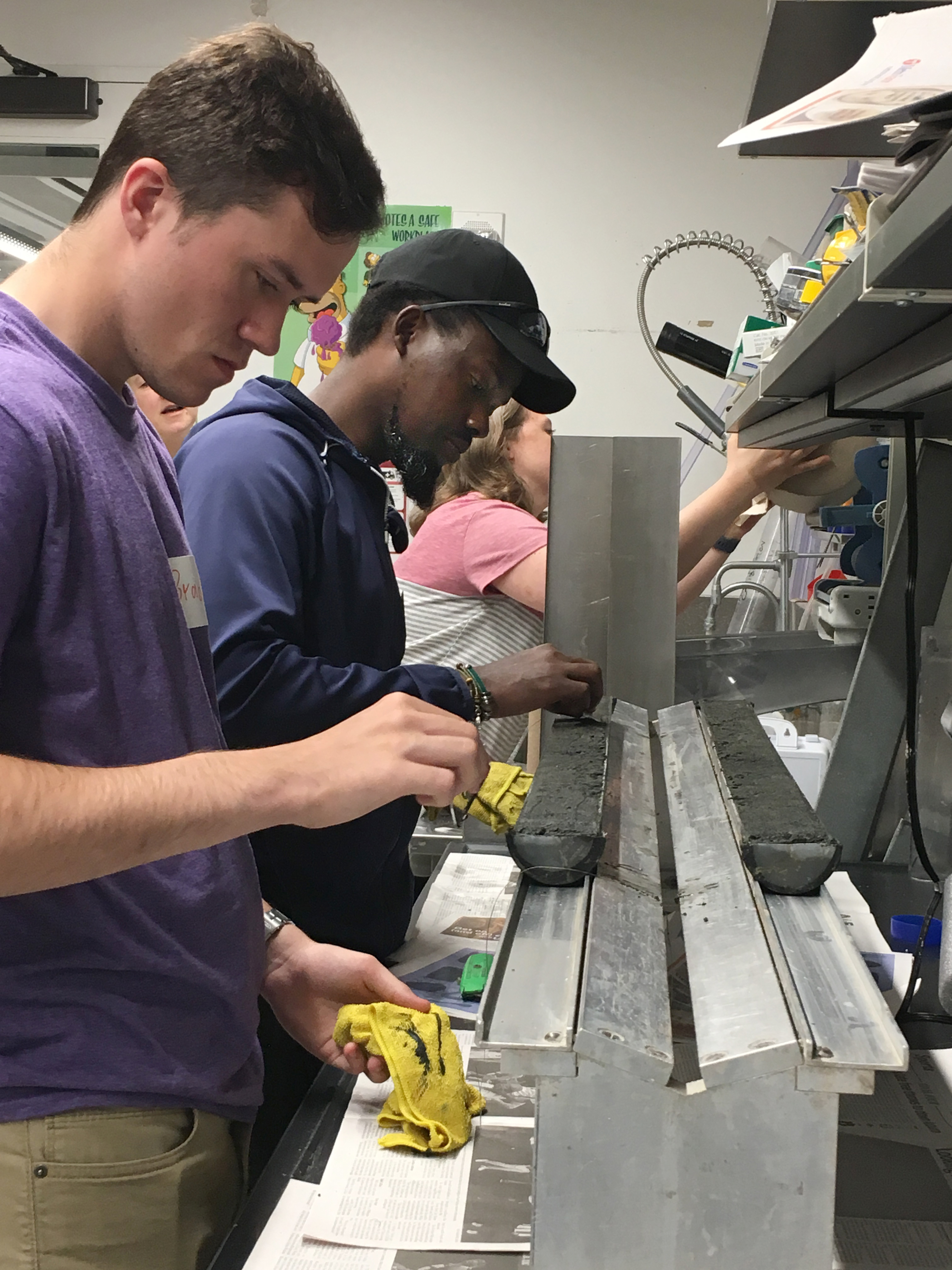 Two undergraduate students learning to split sediment cores
