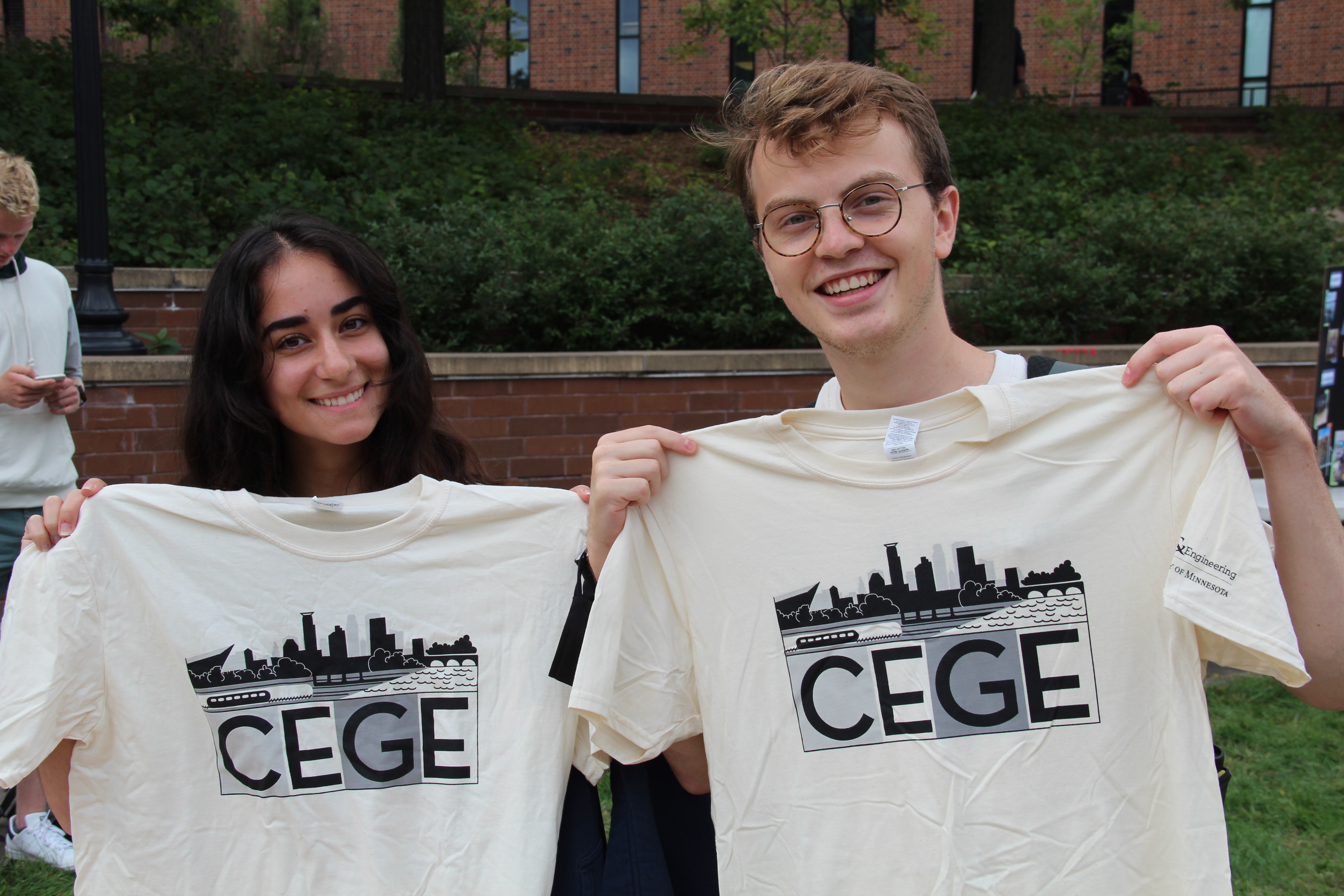 Two students showing off their CEGE t-shirts
