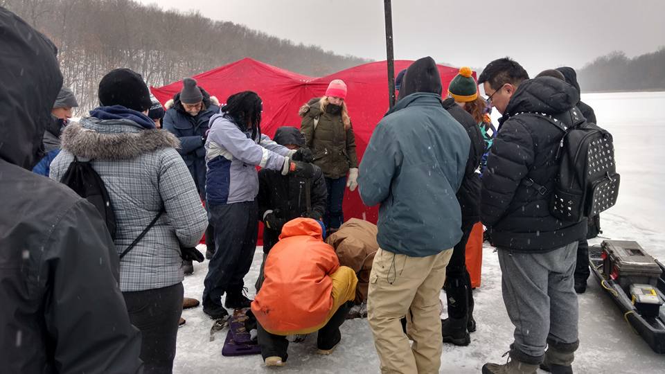 Undergraduate students learn to core through a frozen lake for a lab activity