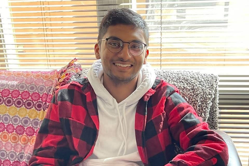 Jeevan Prakash smiles wearing red plaid shirt