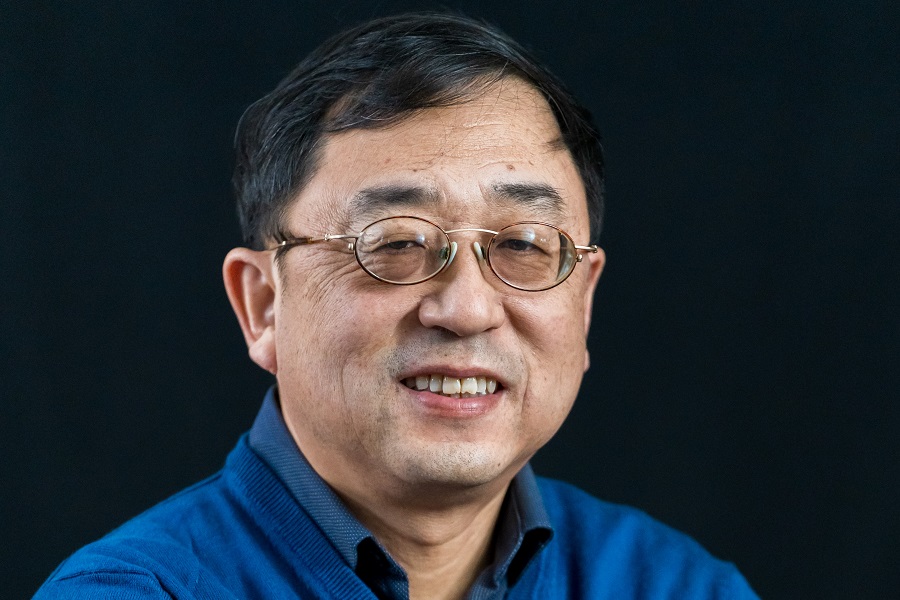 Professor Jian-Ping Wang in blue shirt and blue sweater smiling into the camera