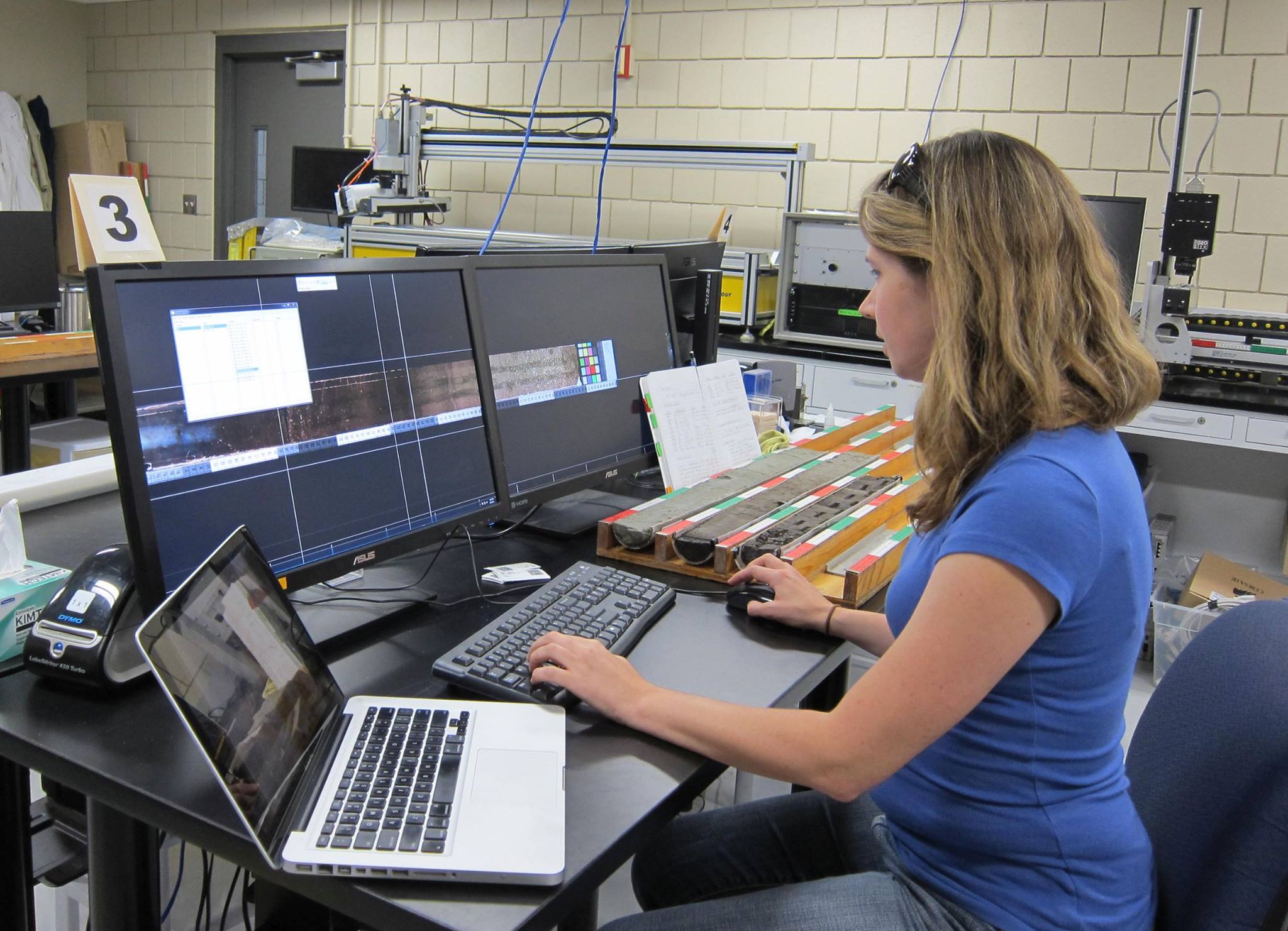 Female graduate student with multiple computers and notebooks uses Corelyzer software to analyze her cores