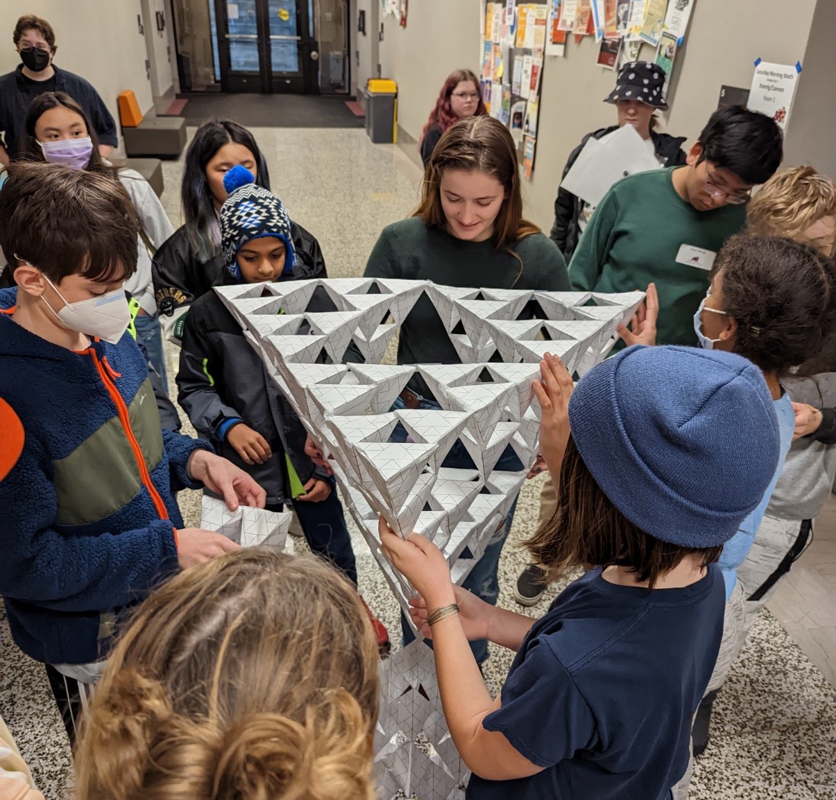 Saturday Morning Math students hold paper Sierpinski Tetrahedron
