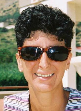 Smiling woman with short dark hair and sunglasses