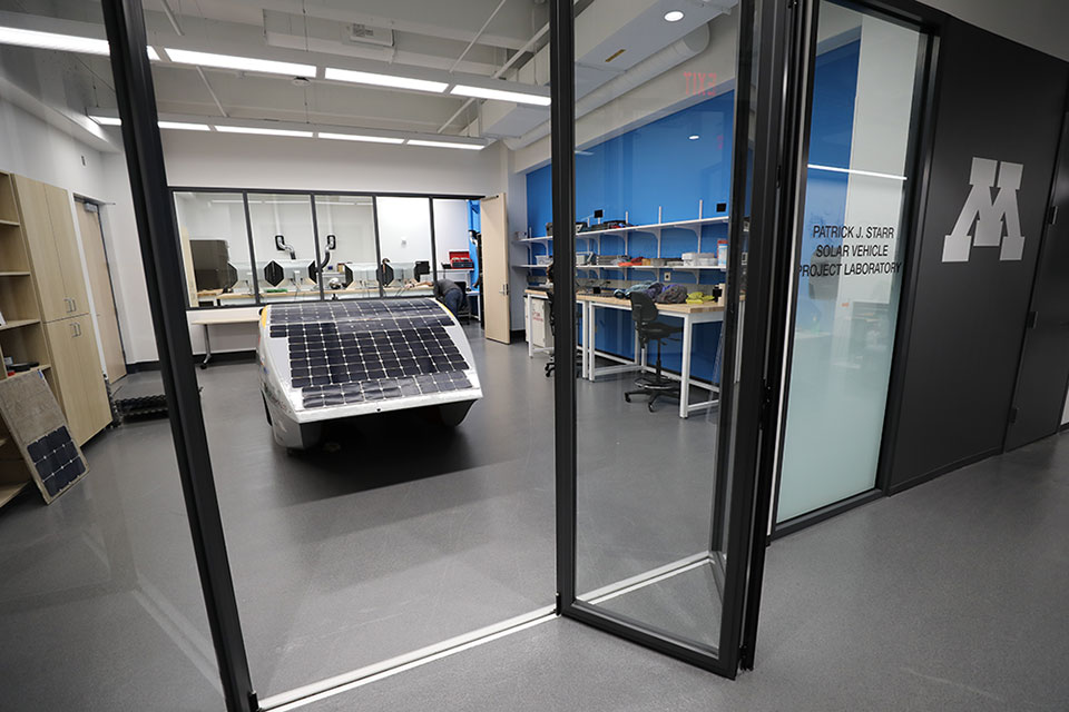 View of Solar Car inside a lab with glass doors that say Patrick J. Starr Solar Vehicle Project Laboratory