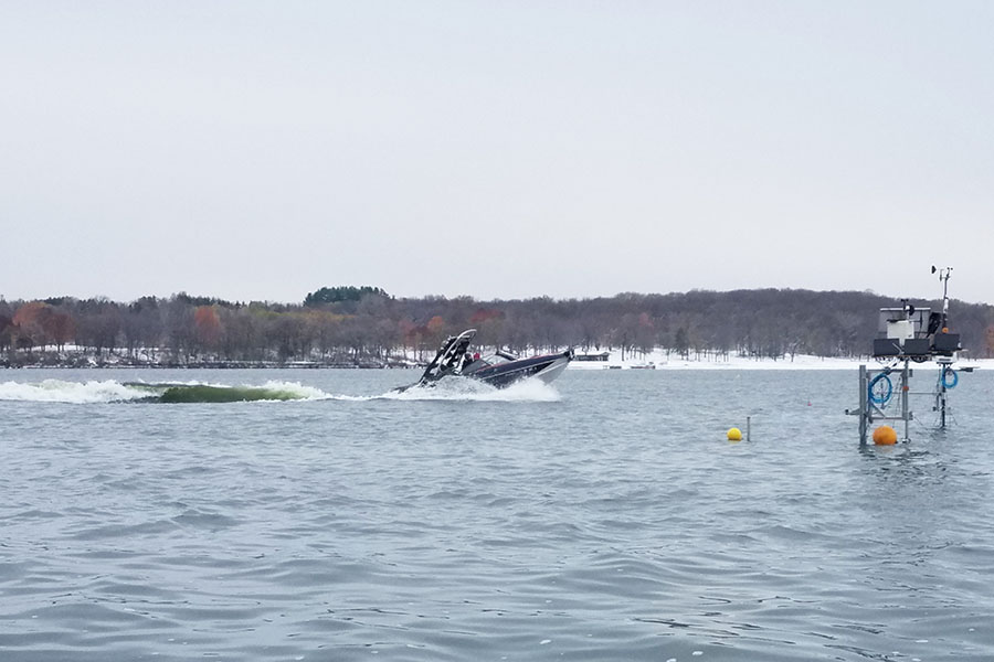 Wakesurf boat on the lake with measurement equipment in the water
