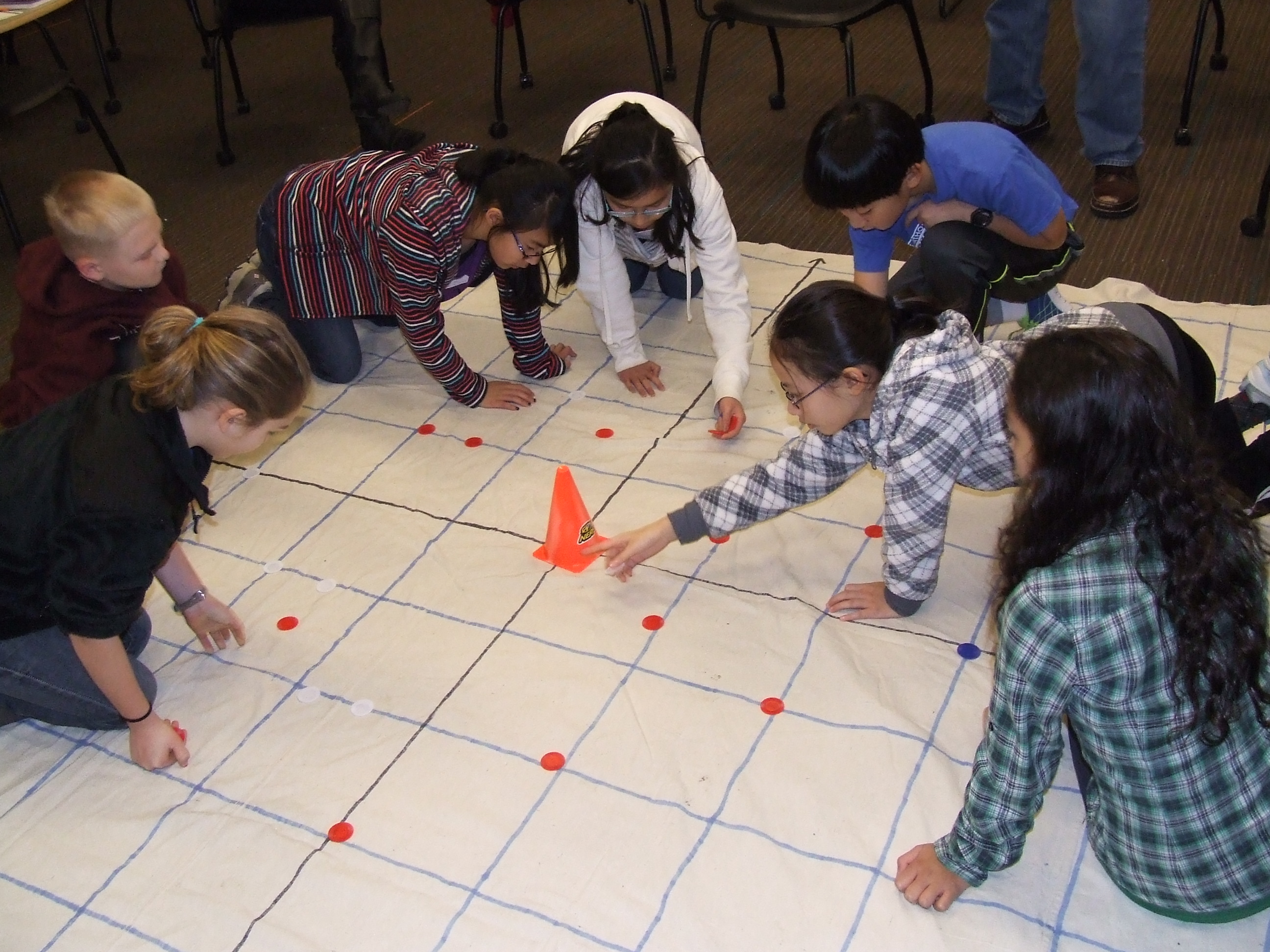 A group of students arranging tokens on a grid