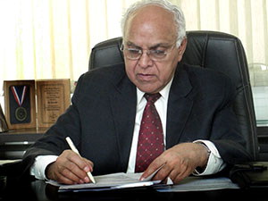 Prem Jain sitting at desk writing notes