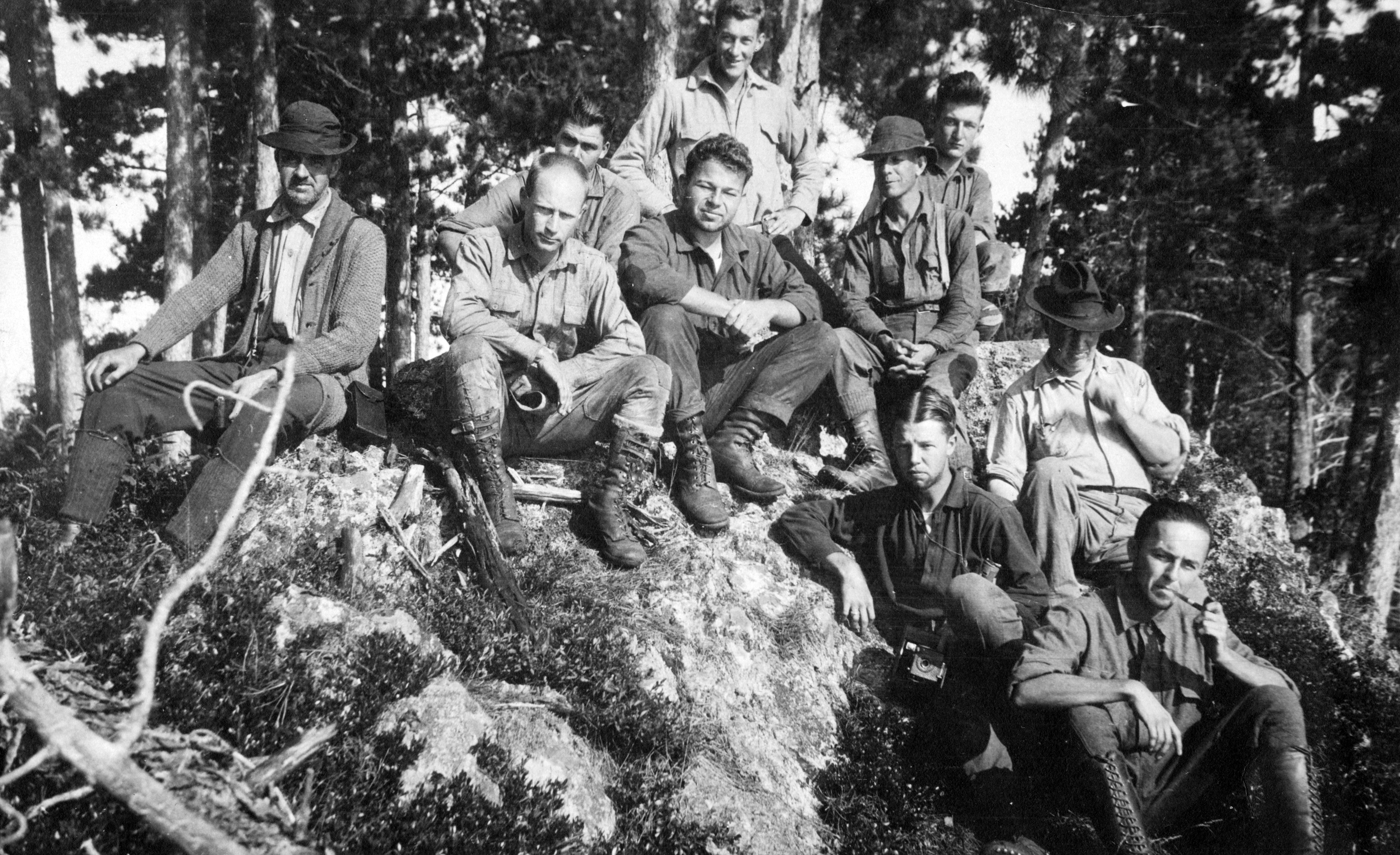 Group of geologists posing on a rock outcropping out in the field. Date unknown.