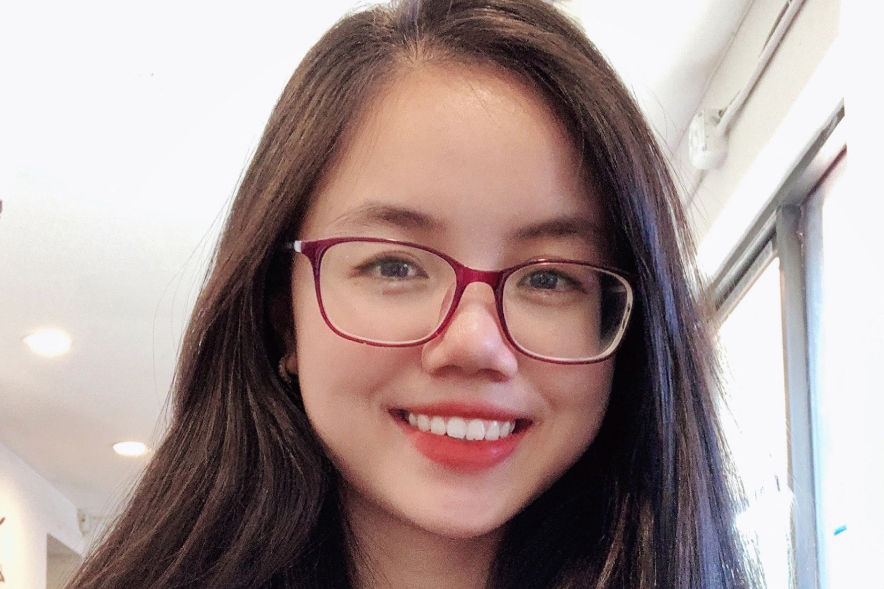 Ngan Nguyen smiles wearing red glasses
