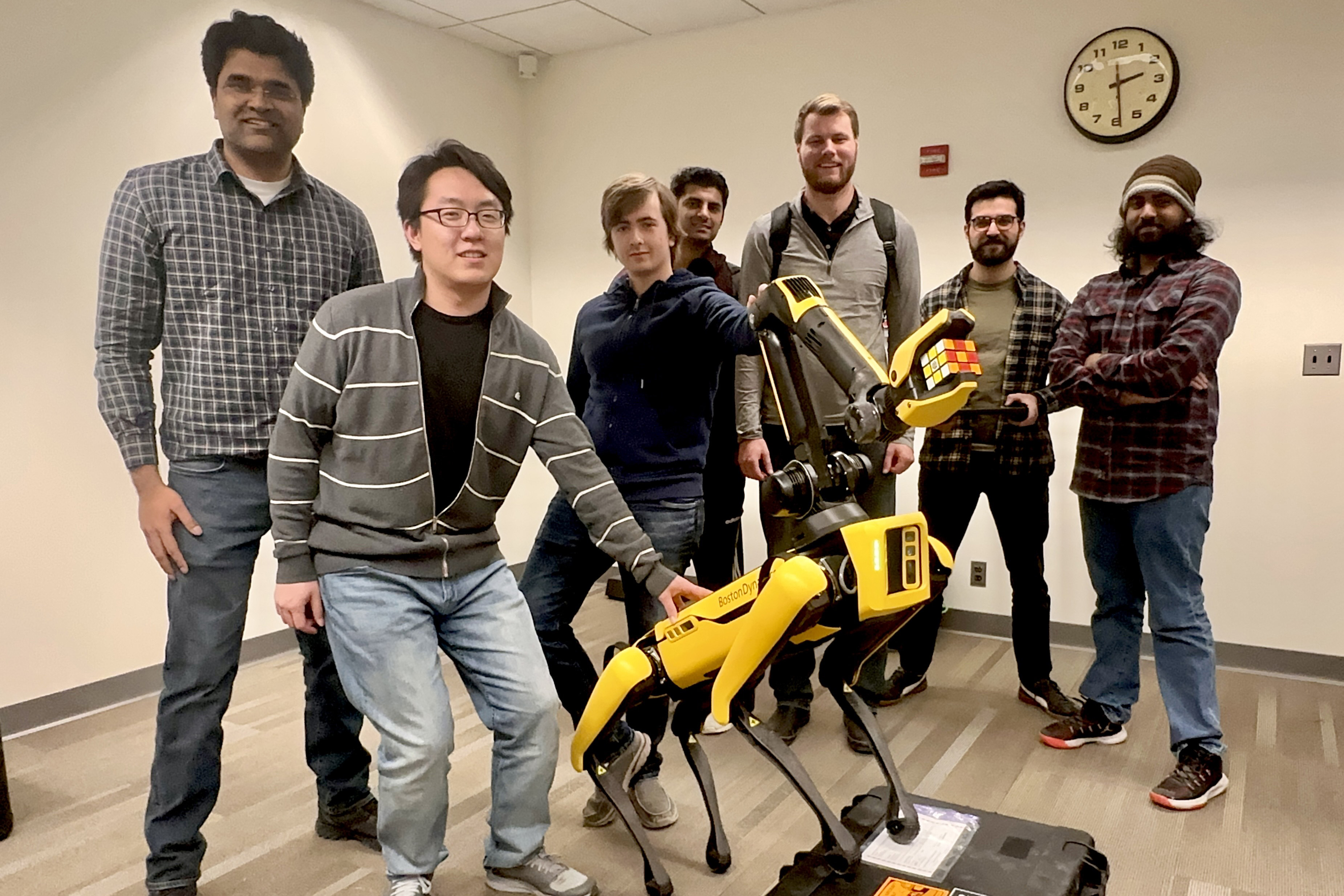 Members of the Robotics: Perception and Manipulation (RPM) Lab pose with the yellow Spot Robot.
