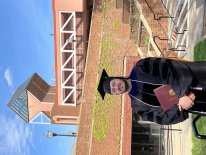 Grant Goedjen in his graduation gown in front of the Civil Engineering Building