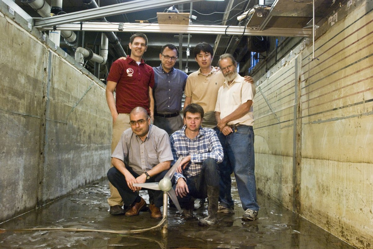 Photo of a research group standing in the main channel next to a turbine