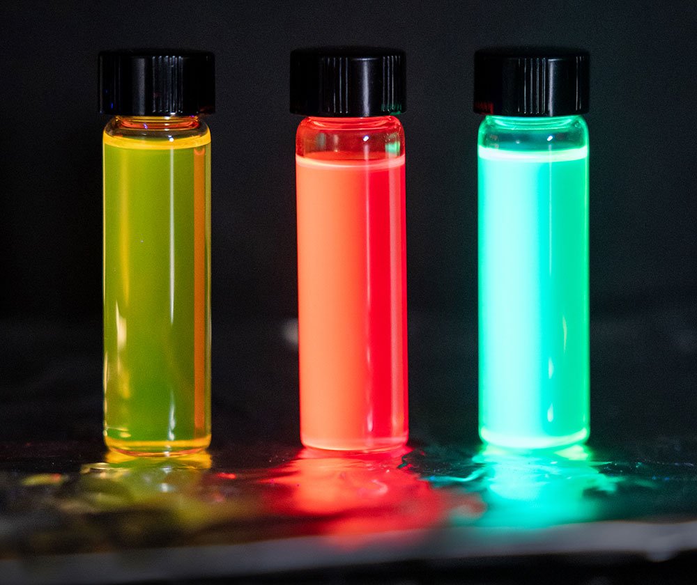 Three vials glow different colors: yellow, red, green
