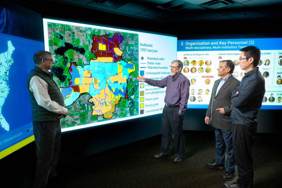 Four CSE researchers looking at an interactive wall map.