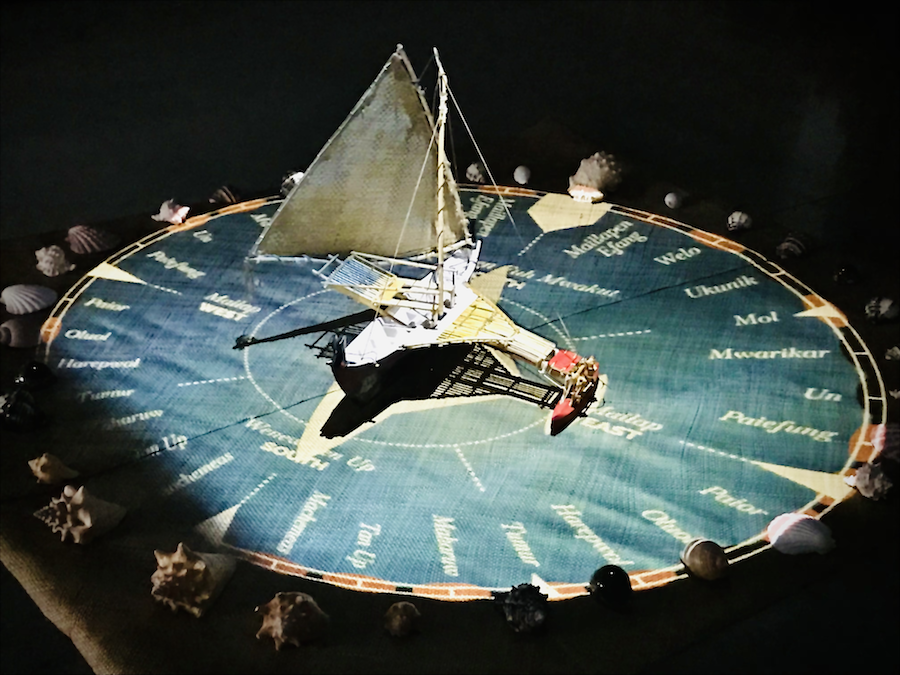 Keefe and Diaz's art installation featuring a model Micronesian canoe sitting on a Paafu mat