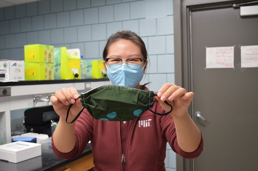 Professor Boya Xiong holds up a face mask in her lab