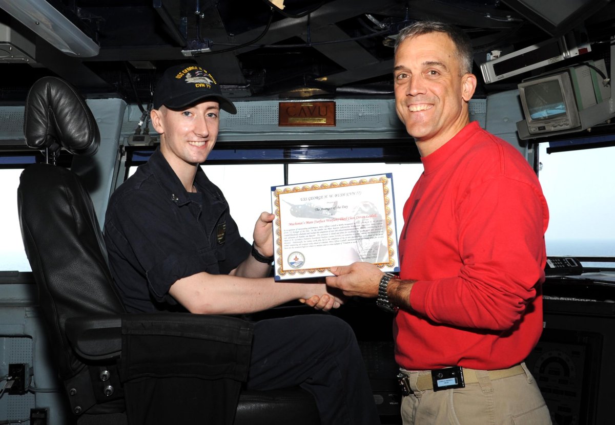 Deven Leidall shakes hands with his commanding officer aboard the USS George H.W. Bush