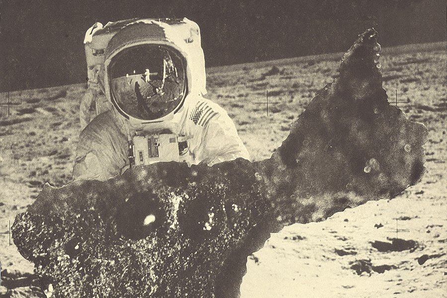 Astronaut holding a giant piece of moon rock.