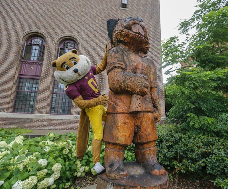 Goldy poses with his own statue wearing a football uniform