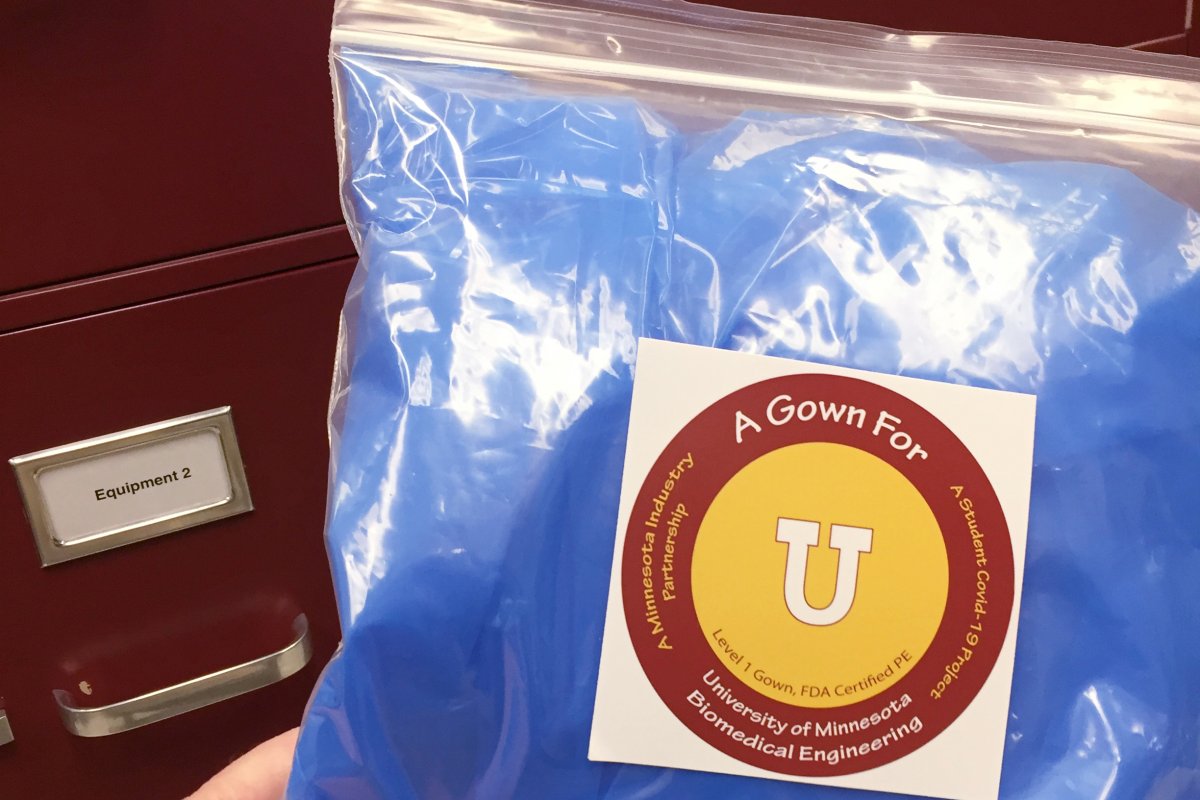 A packaged blue gown with a University of Minnesota sticker.