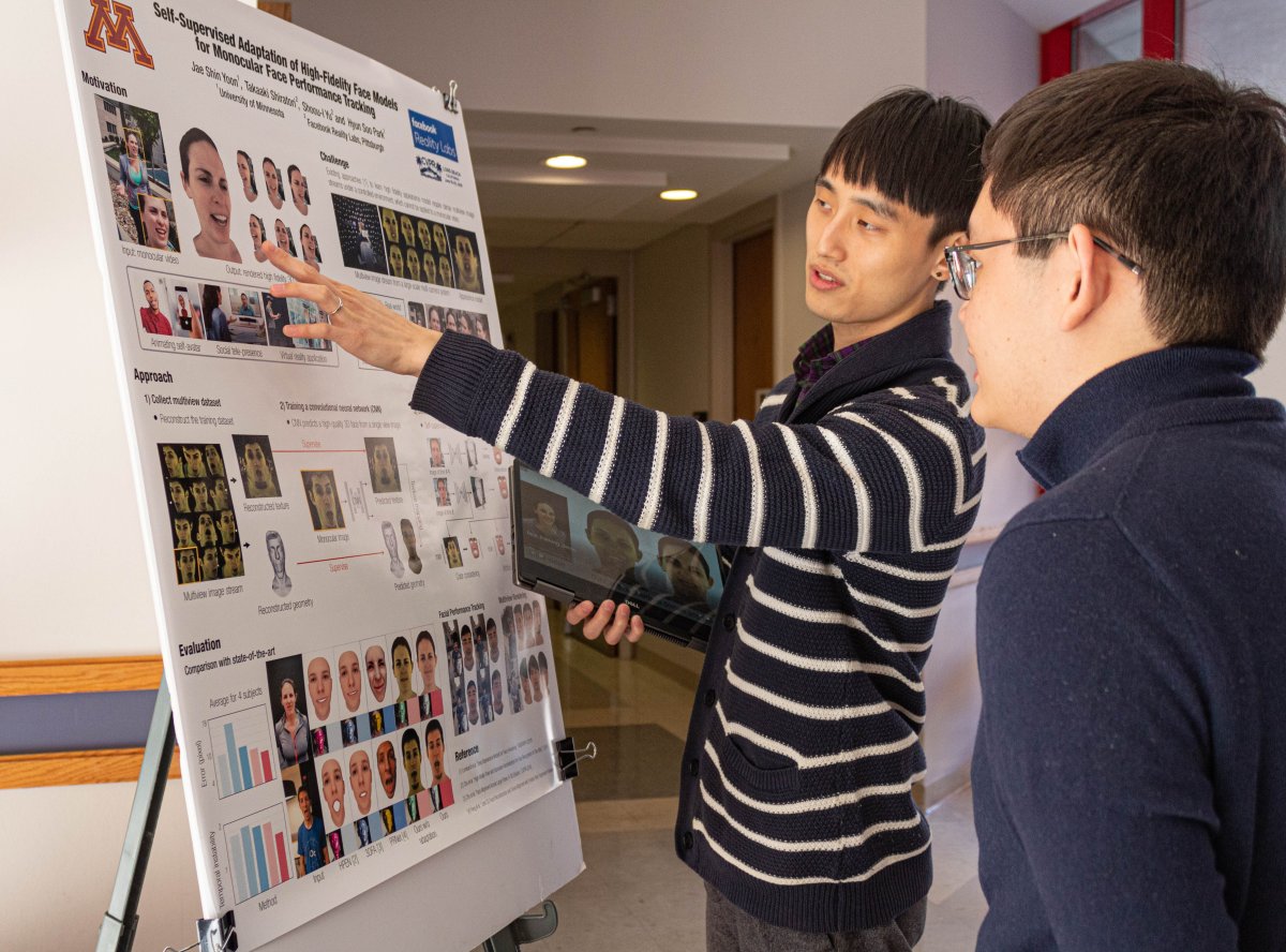 A grad student presenting poster to another