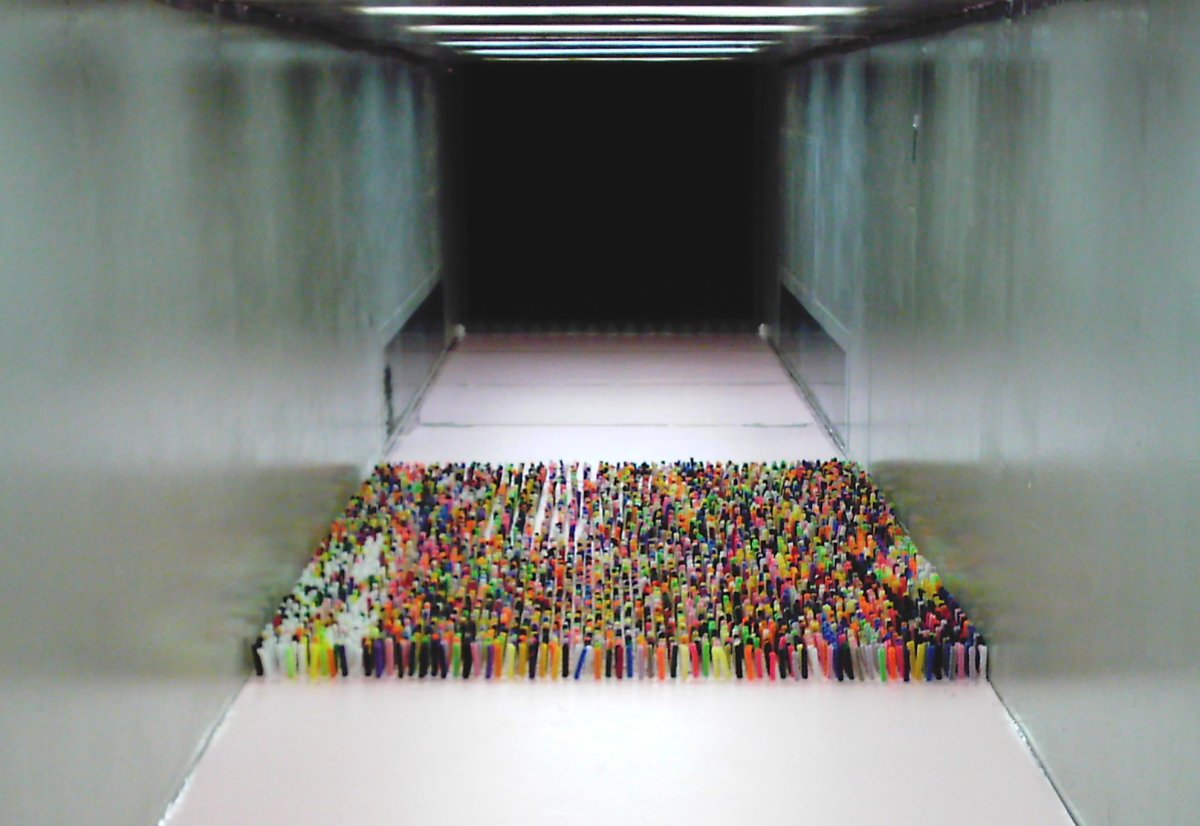 Wind tunnel with an array of colorful pipe cleaners sticking up from the ground