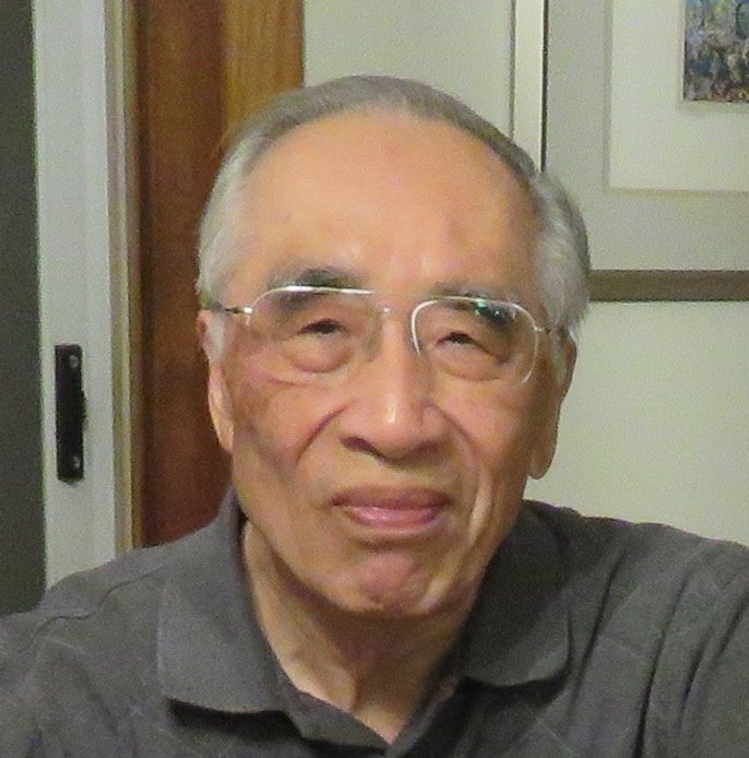 Older man with glasses and gray hair smiling 