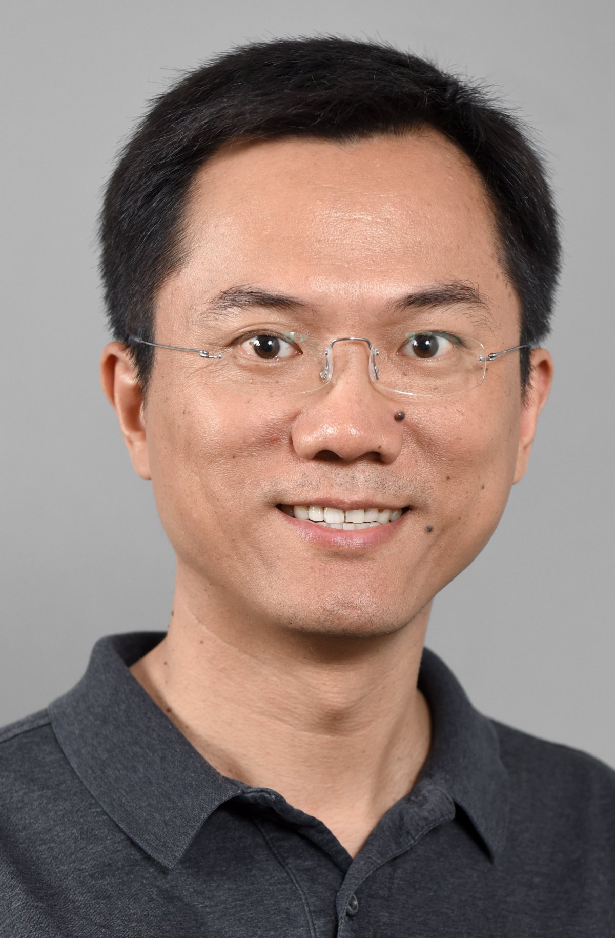 Kevin Cao wearing a dark polo smiling into camera