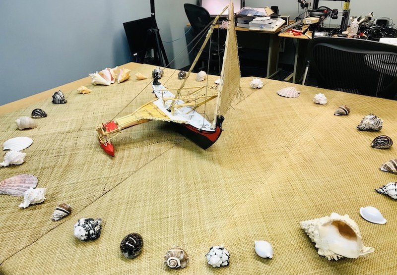 Keefe and Diaz's art installation, which consists of a small canoe sitting on a Paafu mat surrounded by shells, demonstrates a Micronesian navigation technique.