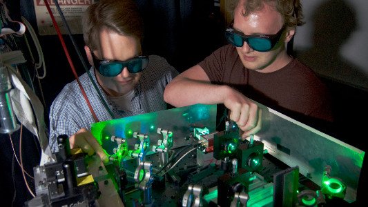 Two students performing research with lasers in the Mueller Lab